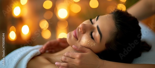 Indian woman enjoying shoulder massage in spa salon.