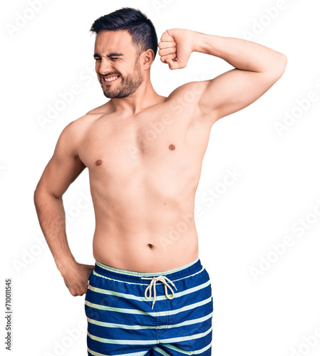 Young handsome man wearing swimwear stretching back, tired and relaxed, sleepy and yawning for early morning