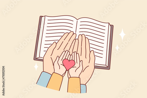 Hands of child and mother over bible with christian prayers, as metaphor for religious education