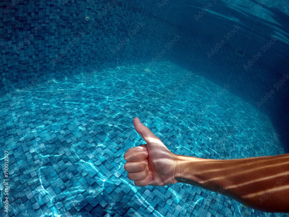 mão fazendo sinal e beleza em água de piscina 