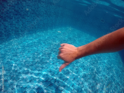 mão fazendo sinal negativo em água de piscina 