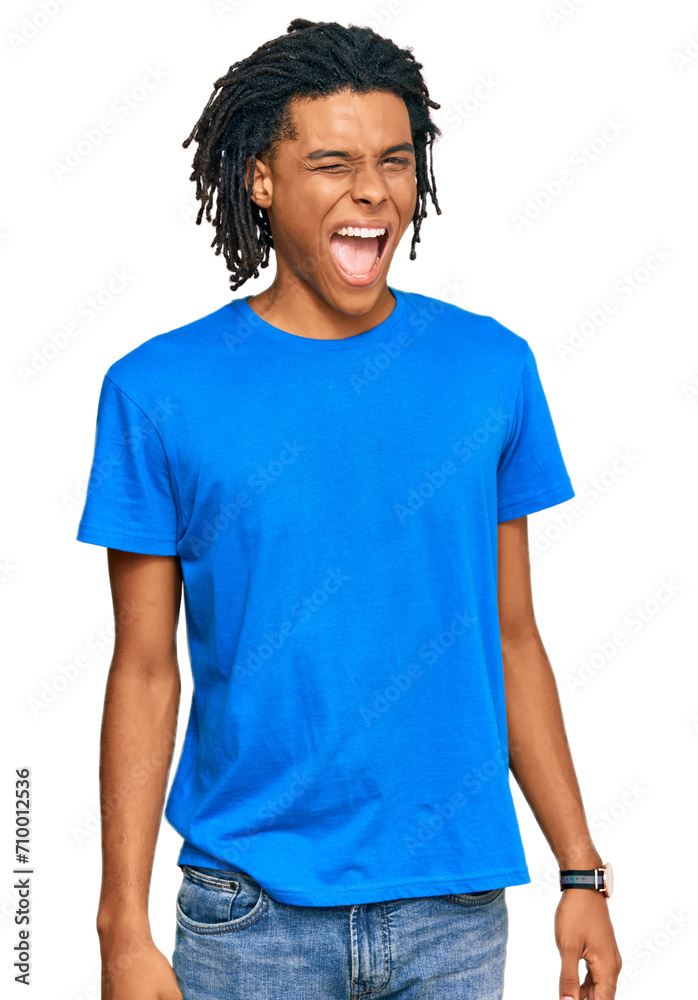 Young african american man wearing casual clothes winking looking at the camera with sexy expression, cheerful and happy face. Young african american man wearing casual clothes winking looking at the camera with sexy expression, cheerful and happy face.