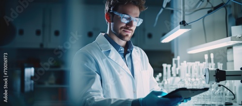 Smiling young caucasian scientist happily holding samples at laboratory