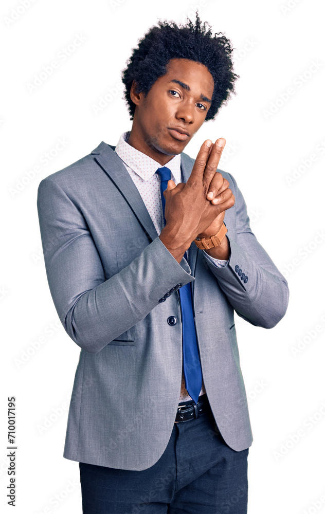 Handsome african american man with afro hair wearing business jacket holding symbolic gun with hand gesture, playing killing shooting weapons, angry face Handsome african american man with afro hair wearing business jacket holding symbolic gun with hand gesture, playing killing shooting weapons, angry face