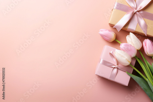 Mother's Day concept. Top view photo of stylish pink giftbox with ribbon bow and bouquet of tulips on isolated pastel pink background with copyspace Generative AI photo