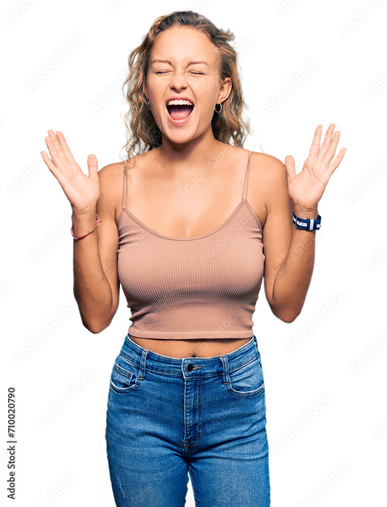 Beautiful caucasian woman wearing casual clothes celebrating mad and crazy for success with arms raised and closed eyes screaming excited. winner concept Beautiful caucasian woman wearing casual clothes celebrating mad and crazy for success with arms raised and closed eyes screaming excited. winner concept