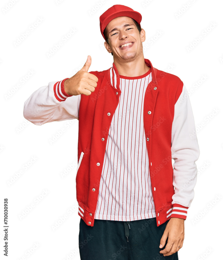 Handsome caucasian man wearing baseball uniform doing happy thumbs up gesture with hand. approving expression looking at the camera showing success. Handsome caucasian man wearing baseball uniform doing happy thumbs up gesture with hand. approving expression looking at the camera showing success.