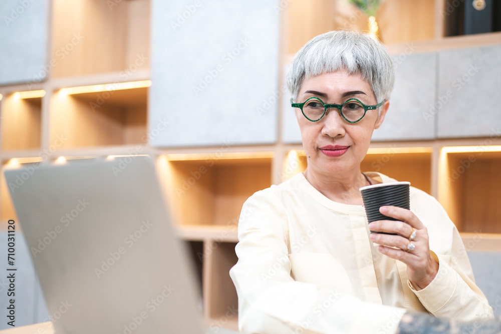 Fashionable Smart confidence, skillful Senior adult or retired female architect, designer enjoying her coffee time while working online at her modern office, Elderly creativity businesswoman lifestyle Fashionable Smart confidence, skillful Senior adult or retired female architect, designer enjoying her coffee time while working online at her modern office, Elderly creativity businesswoman lifestyle