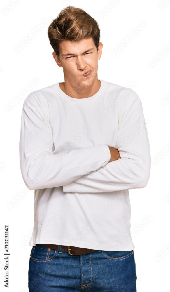 Handsome caucasian man wearing casual white sweater skeptic and nervous, disapproving expression on face with crossed arms. negative person. Handsome caucasian man wearing casual white sweater skeptic and nervous, disapproving expression on face with crossed arms. negative person.