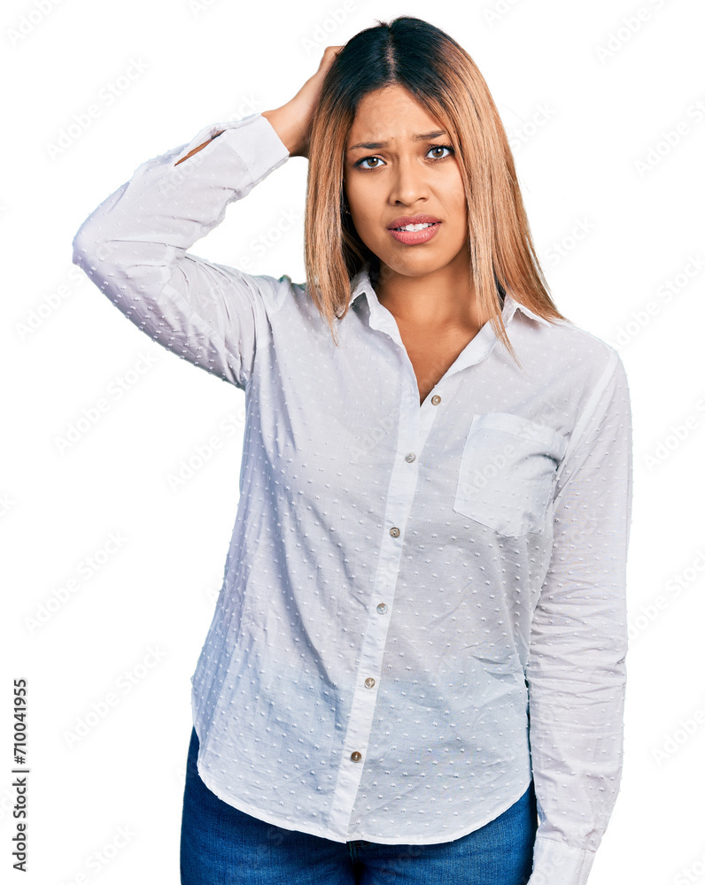 Young hispanic woman wearing casual white shirt confuse and wonder about question. uncertain with doubt, thinking with hand on head. pensive concept. Young hispanic woman wearing casual white shirt confuse and wonder about question. uncertain with doubt, thinking with hand on head. pensive concept.