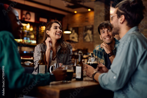 Group of happy friends enjoying in beer and conversation in pub.
