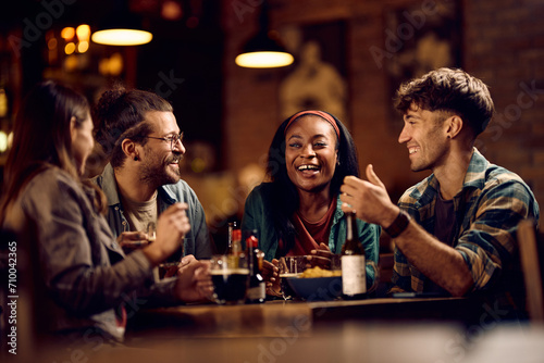 Cheerful black woman having fun with her friends in bar.