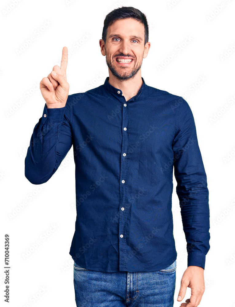 Young handsome man wearing casual shirt showing and pointing up with finger number one while smiling confident and happy. Young handsome man wearing casual shirt showing and pointing up with finger number one while smiling confident and happy.