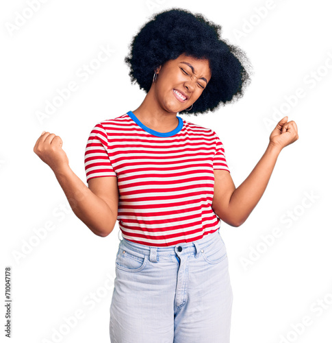 Young african american girl wearing casual clothes very happy and excited doing winner gesture with arms raised, smiling and screaming for success. celebration concept.