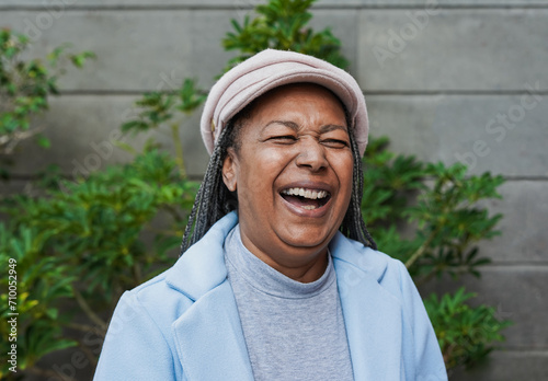 Фотография Happy african senior woman laughing in front of camera during winter time outsid