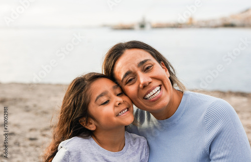 Happy latin mother and daughter having fun together outdoor in front of camera