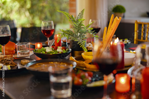 Fototapeta Naklejka Na Ścianę i Meble -  Cozy holiday table with different delicious food, beverages and candles ready for friends home party