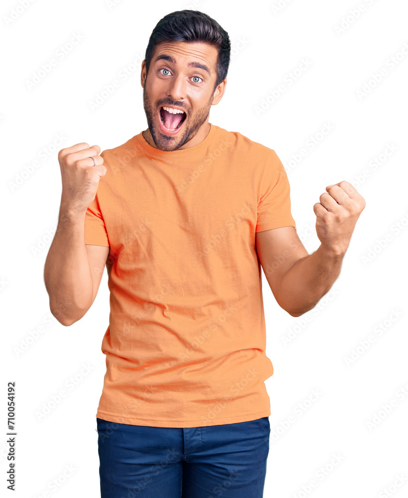 Fototapeta premium Young hispanic man wearing casual clothes screaming proud, celebrating victory and success very excited with raised arms