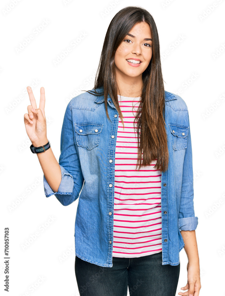 Young brunette woman wearing casual clothes smiling looking to the camera showing fingers doing victory sign. number two. Young brunette woman wearing casual clothes smiling looking to the camera showing fingers doing victory sign. number two.