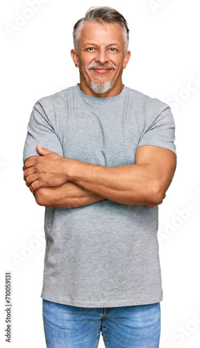 Middle age grey-haired man wearing casual clothes happy face smiling with crossed arms looking at the camera. positive person.