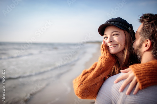 Couple embracing on a beach during autumn photo
