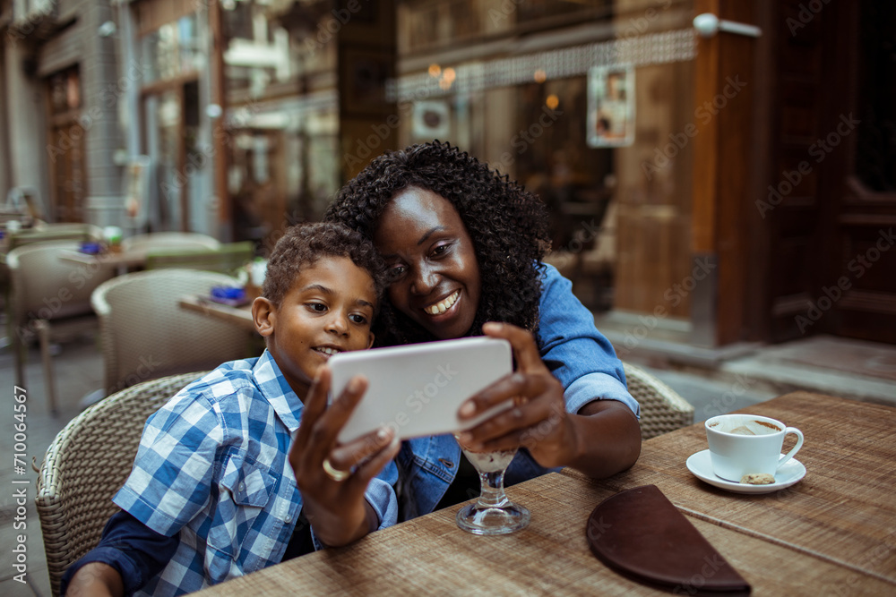 Mother and Son Enjoying a Video Call at an Outdoor Cafe Mother and Son Enjoying a Video Call at an Outdoor Cafe