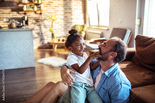 Father having fun with little daughter at home photo