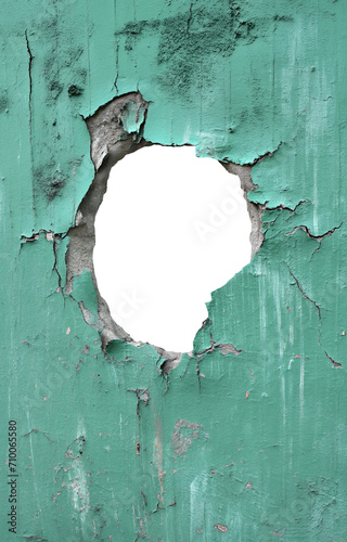 torn hole in a old cracked mint green concrete wall. Peeling old mint green paint. Cracked and peeling, Grunge wall texture. Worn aged post apocalyptic texture background with a hole in the wall.