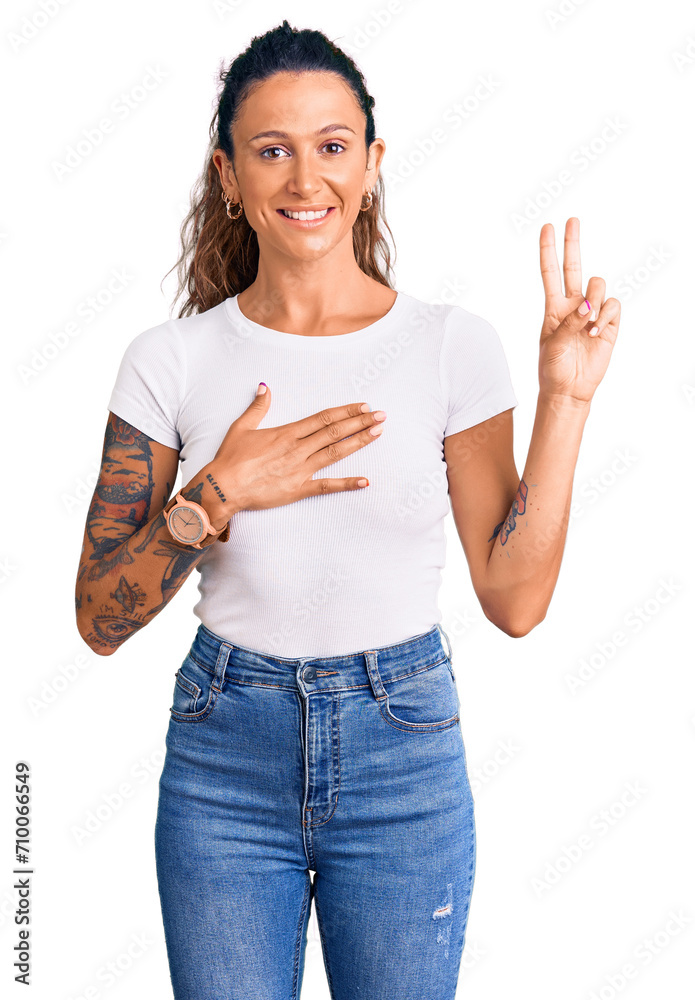 Obraz premium Young hispanic woman with tattoo wearing casual white tshirt smiling swearing with hand on chest and fingers up, making a loyalty promise oath