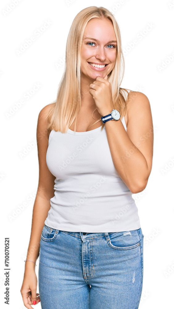 Fototapeta premium Young blonde girl wearing casual style with sleeveless shirt looking confident at the camera smiling with crossed arms and hand raised on chin. thinking positive.