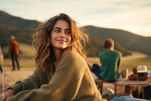 Smiling Young Woman Enjoying Outdoors with Friends at Sunset