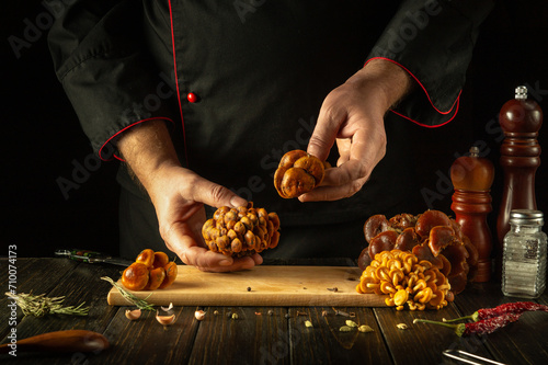 Flammulina velutipes in the hands of a chef before being sorted and prepared in the hotel kitchen. Delicious dietary lunch made from fresh raw velvet stem photo