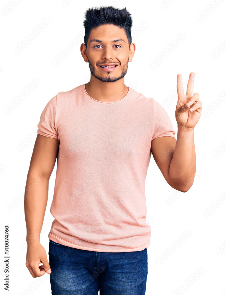 Handsome latin american young man wearing casual clothes smiling with happy face winking at the camera doing victory sign. number two. Handsome latin american young man wearing casual clothes smiling with happy face winking at the camera doing victory sign. number two.