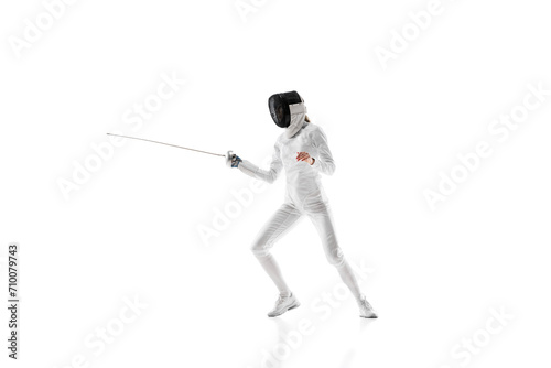 Self-defense skills. Although sportive, fencing skills can represent the broader theme of self-defense. Female athlete in motion, training over white background. Concept of sport, competition, hobby