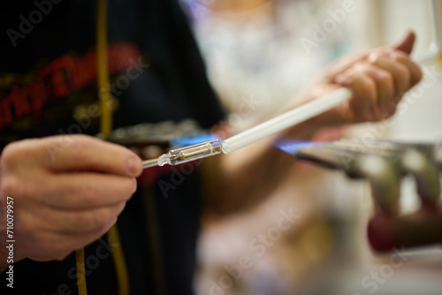 neon glass blower using fire to melt electrode to neon glass tube
