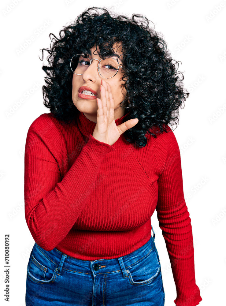 Young middle east girl wearing casual clothes and glasses hand on mouth telling secret rumor, whispering malicious talk conversation