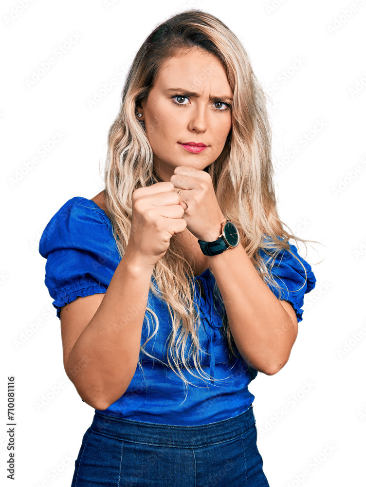 Young blonde woman wearing casual clothes ready to fight with fist defense gesture, angry and upset face, afraid of problem Young blonde woman wearing casual clothes ready to fight with fist defense gesture, angry and upset face, afraid of problem
