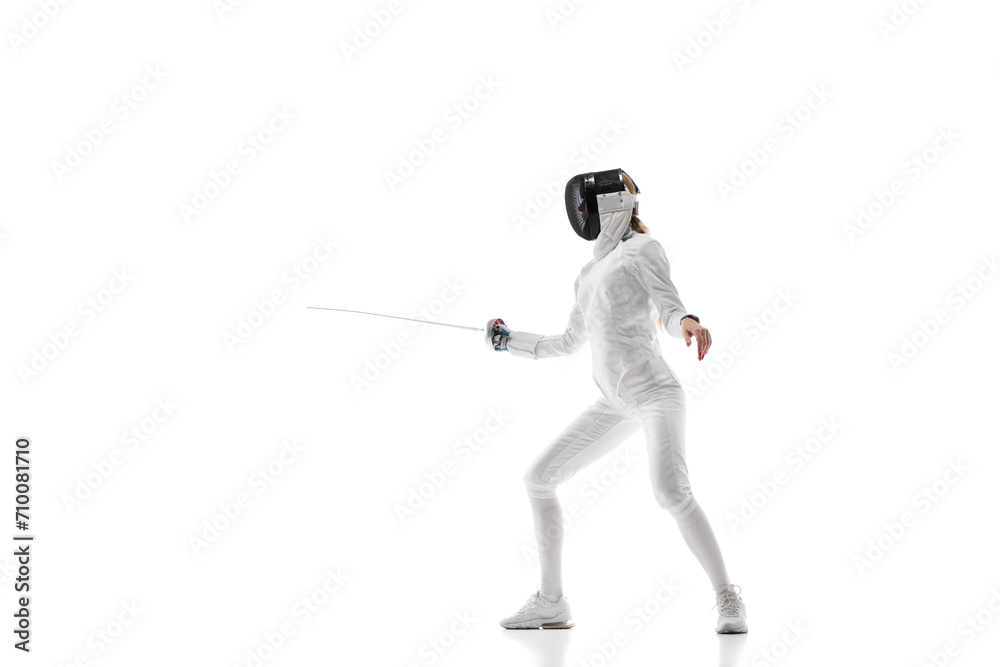 Sports training. An athlete demonstrating the skill and form developed through dedicated sports training. Female fencer in motion over white background. Concept of sport, competition, championship
