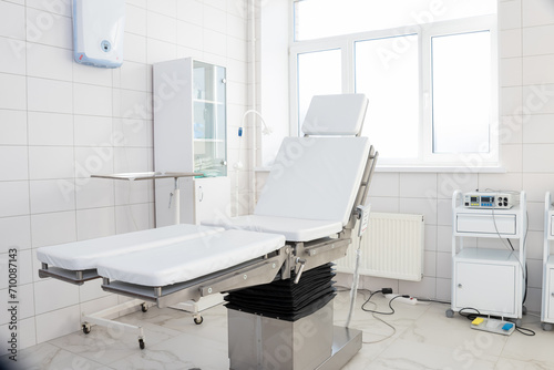 Hospital interior design with operating table and lamp with cabinets and modern devices in light surgery room.modern equipment in the hospital © Yulia
