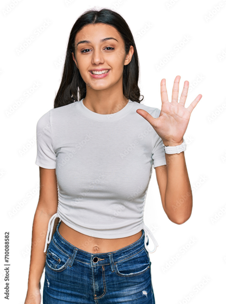 Young hispanic girl wearing casual white t shirt showing and pointing up with fingers number five while smiling confident and happy. Young hispanic girl wearing casual white t shirt showing and pointing up with fingers number five while smiling confident and happy.