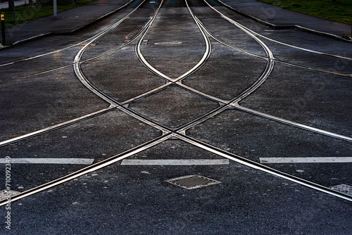 Tram tracks in a t-crossing at sunset.