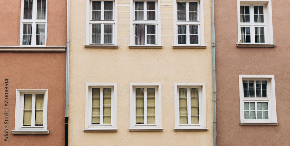 The facade of house with white windows. Windows of an old typical apartment building made of panels