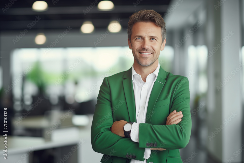 Obraz premium happy businessman ceo, man, standing in office arms crossed, in green jacket, elegant, slim