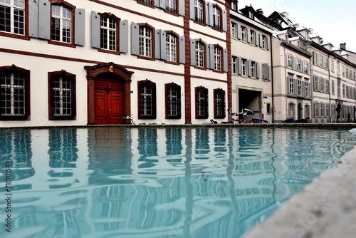 Fassaden spiegeln sich auf dem Sch  neck-Brunnen in Basel