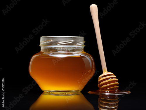 a jar of honey next to a stick