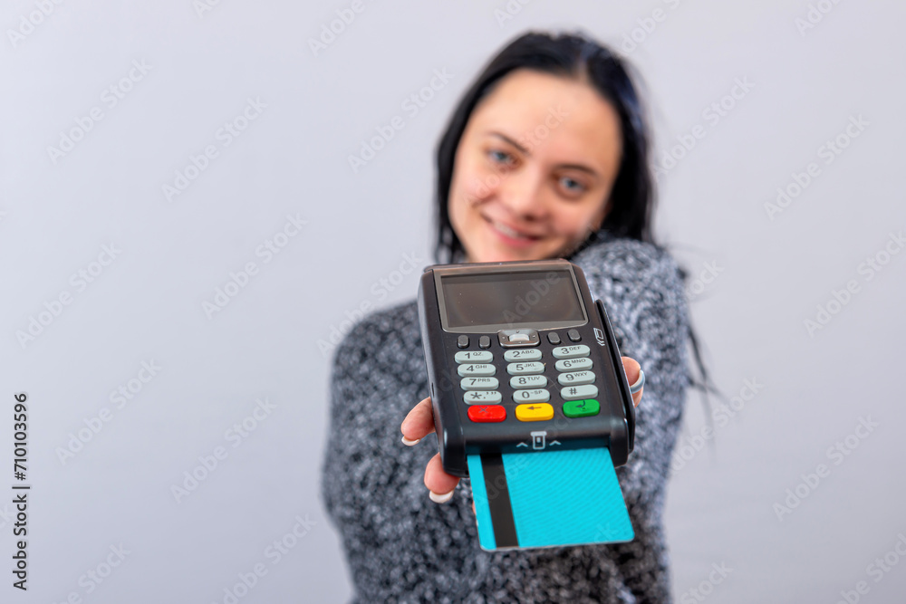 caucasian woman holding payment terminal and giving it to the customer can pay with credit card caucasian woman holding payment terminal and giving it to the customer can pay with credit card