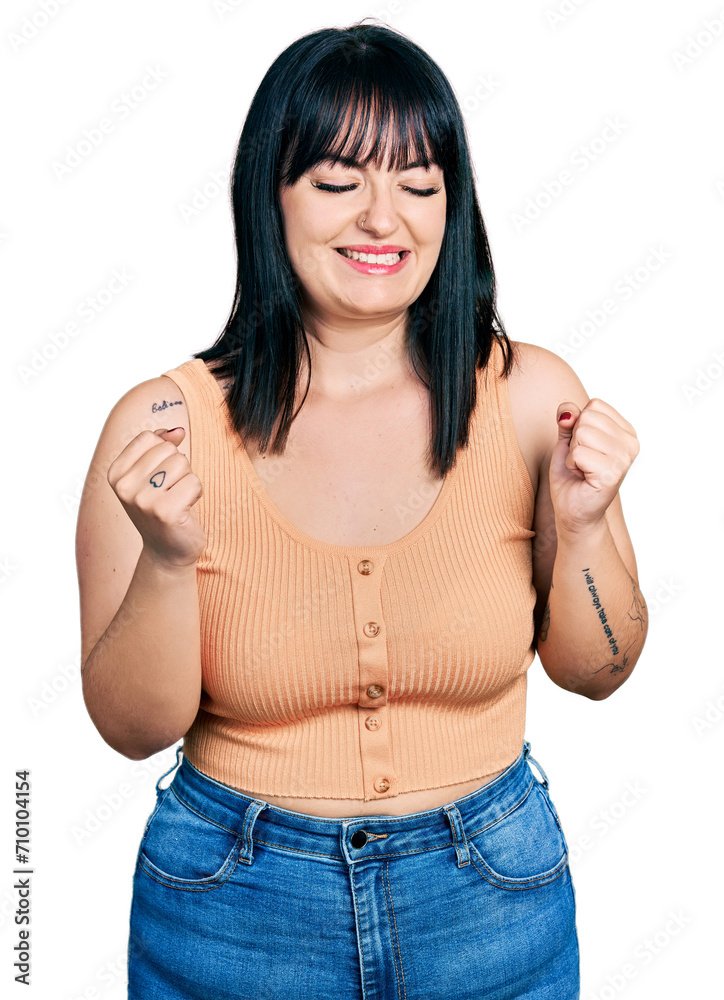 Young hispanic plus size woman wearing casual clothes very happy and excited doing winner gesture with arms raised, smiling and screaming for success. celebration concept. Young hispanic plus size woman wearing casual clothes very happy and excited doing winner gesture with arms raised, smiling and screaming for success. celebration concept.