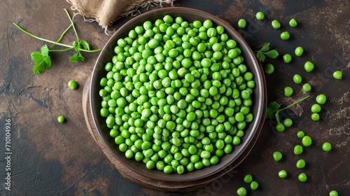 Fresh peas in a bowl on a gray background 
