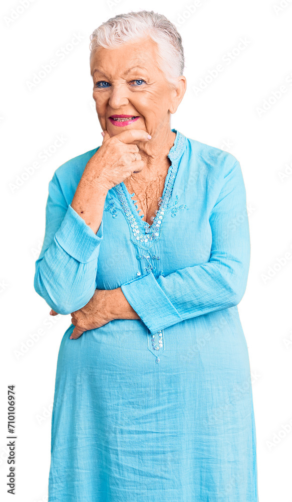 Senior beautiful woman with blue eyes and grey hair wearing summer dress looking confident at the camera smiling with crossed arms and hand raised on chin. thinking positive. Senior beautiful woman with blue eyes and grey hair wearing summer dress looking confident at the camera smiling with crossed arms and hand raised on chin. thinking positive.
