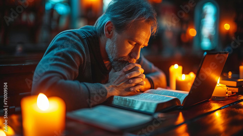 Mature man praying in front of bible photo